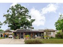 Charming single-story home featuring solar panels, a screened porch, and a covered carport at 4015 Asbury Pl, Sarasota, FL 34233