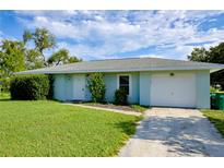 Charming single-story home with a well-manicured lawn and attached one car garage at 478 Orange Nw Dr, Port Charlotte, FL 33952
