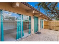 Home exterior featuring a brick patio, sliding glass doors, and vibrant turquoise trim at 500 N Jefferson Ave # G5, Sarasota, FL 34237
