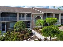 Condo's exterior shows a well-maintained facade with landscaping and a sidewalk leading to the entrance at 5330 Hyland Hills Ave # 2324, Sarasota, FL 34241