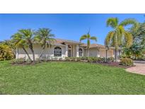 Beautiful home with a well-manicured lawn, mature landscaping, and palm trees, offering great curb appeal at 5698 Country Walk Ln, Sarasota, FL 34233