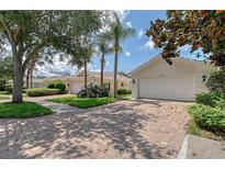 Charming home with brick driveway, lush landscaping, and two-car garage at 5787 Ivrea Dr, Sarasota, FL 34238