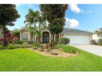 Charming single-story home with lush landscaping, rock water feature, and a well-manicured lawn at 5905 32Nd E St, Ellenton, FL 34222