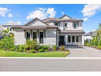Charming two-story home with a three-car garage, well-manicured lawn, and a paver driveway at 6349 Isla Del Ray Ave, Sarasota, FL 34240