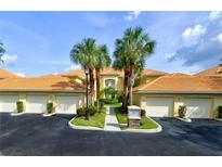 Charming, well-maintained condo with attached garages, beautiful landscaping, and palm trees at 7155 Boca Grove Place Pl # 202, Lakewood Ranch, FL 34202