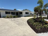 Beautifully landscaped home featuring a curved driveway with well-manicured plants and fresh white gravel at 808 25Th W Ave, Palmetto, FL 34221