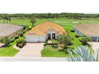 Beautiful single Gathering home with a tile roof, brick driveway and pristine landscaping, backing onto a golf course at 8206 Heritage Grand Pl, Bradenton, FL 34212