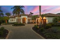 Elegant Mediterranean-style home featuring a circular driveway, lush landscaping, and a grand entrance at 8312 Catamaran Cir, Lakewood Ranch, FL 34202