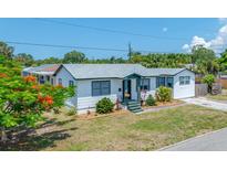 Charming single-story home featuring white siding, green trim, and well-maintained front yard landscaping at 440 42Nd N St, St Petersburg, FL 33713