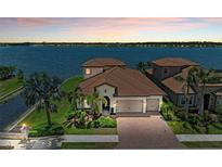 Stunning waterfront home featuring lush landscaping, a paver driveway, and a tile roof at 501 Maraviya Blvd, Nokomis, FL 34275