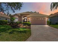Beautiful single-story home featuring a well-manicured lawn, tile roof, and paved driveway leading to the two-car garage at 5074 Flagstone Dr, Sarasota, FL 34238