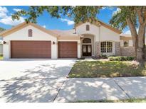 Charming single-story home with a well-manicured lawn and a three-car garage, set under a beautiful blue sky at 5240 Silver Charm Ter, Wesley Chapel, FL 33544