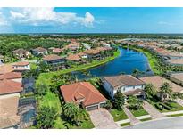 Beautiful aerial view of houses surrounding a long lake, and tropical landscaping in a wonderful neighborhood at 5511 Foxfire Run, Lakewood Ranch, FL 34211