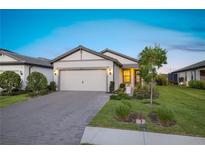 Charming single-story home with a two-car garage, manicured lawn, and a welcoming entrance at 6239 Baywood Ct, Bradenton, FL 34211