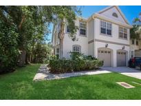 Inviting townhome with a two-car garage, lush landscaping, and a well-maintained lawn at 656 Vallance Ne Way, St Petersburg, FL 33716
