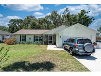 Charming single-story home with well-maintained lawn, lush landscaping, and a parked car at 712 68Th W Ave, Bradenton, FL 34207