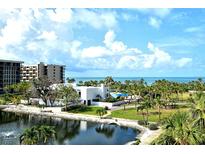 Beautiful aerial view of a waterfront condo building with lush landscaping and ocean views at 1115 Gulf Of Mexico Dr # 304, Longboat Key, FL 34228
