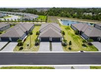 An aerial view of the neighborhood showcasing well-manicured lawns, a pond, and charming single-Gathering homes at 2016 Bonito Way, Port Charlotte, FL 33953