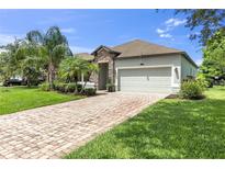 Charming home featuring a brick driveway, manicured lawn and stone facade, creating inviting curb appeal at 2334 50Th Street E Cir, Palmetto, FL 34221