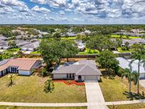 Charming single-story home with well-maintained landscaping and a long driveway in a lush, green neighborhood at 4155 Center Gate Blvd, Sarasota, FL 34233