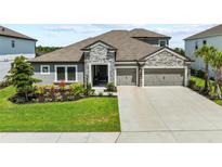 Charming single-Gathering home featuring a stone facade, well-manicured lawn, and a two-car garage at 4430 Pond Brook Ct, Bradenton, FL 34211