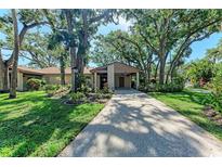 Charming home exterior with mature trees and lush landscaping creating a serene and inviting atmosphere at 5109 28Th W St, Bradenton, FL 34207
