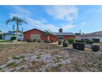 Single-story home featuring well-maintained landscaping, complemented by palm trees against a partly cloudy sky at 5114 36Th Avenue W Dr, Bradenton, FL 34209