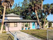 Charming single-Gathering home with a vibrant blue front door and beautiful tropical landscaping at 5439 3Rd E St, Bradenton, FL 34203