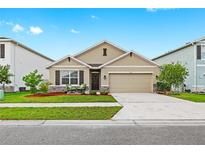 Charming single-Gathering home featuring a well-manicured lawn, neutral exterior, and a two-car garage at 5659 Woodland Sage Dr, Sarasota, FL 34238