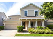 Charming two-story home featuring a covered front porch, well-maintained landscaping, and an attached two-car garage at 7113 Park Tree Dr, Tampa, FL 33625