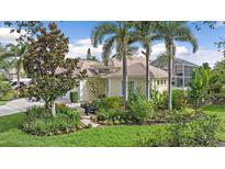 Beautiful exterior view of a home with lush landscaping, palm trees, and a tiled roof at 7507 Ascot Ct, Bradenton, FL 34201