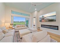 Cozy living room with a serene view, featuring comfortable seating, a fireplace, and access to the outdoors at 7507 Ascot Ct, University Park, FL 34201