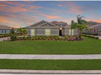 Charming home featuring a lush green lawn, well-manicured landscaping, and a tile roof at 7508 Ripetta St, Sarasota, FL 34240