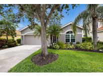 Charming single-story home featuring a manicured lawn and a two-car garage at 8640 Stone Harbour Loop, Bradenton, FL 34212