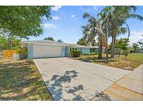 Charming single-story home with a well-manicured lawn, mature trees, and an attached two-car garage at 139 Adair Ave, Sarasota, FL 34243