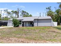 Charming single-story home featuring gray paint and a well-manicured front yard at 16834 Toledo Blade Blvd, Port Charlotte, FL 33954