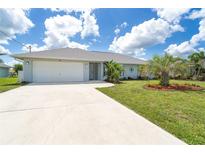Charming single-story home with a well-manicured lawn, landscaping, and a two-car garage at 217 Mariner Ln, Rotonda West, FL 33947