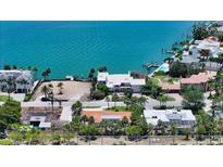 Charming waterfront property featuring a cozy home with a red tile roof, surrounded by lush tropical greenery at 223 Seagull Ln, Sarasota, FL 34236