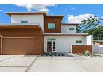 Contemporary home featuring clean lines, a flat roof, wood accents, and manicured landscaping at 2314 Floyd St, Sarasota, FL 34239