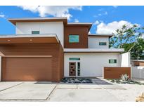 Stunning modern two-story home with a flat roof, brown accents, landscaped front yard, and a two-car garage at 2314 Floyd St, Sarasota, FL 34239