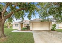 Charming single-story home with a two-car garage, manicured lawn, and mature tree providing ample shade at 3415 68Th Street E Cir, Palmetto, FL 34221
