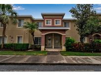 Townhouse exterior featuring well-maintained landscaping, an appealing archway entrance, and a neutral color scheme at 3707 45Th W Ter # 104, Bradenton, FL 34210