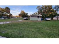 Charming home with green siding, a screened porch, and a large lawn at 4223 Sawyer Rd, Sarasota, FL 34233