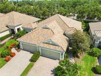 Aerial view of home featuring a tile roof, brick driveway, and well-maintained landscaping at 5418 Fairfield Blvd, Bradenton, FL 34203