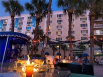 Relaxing outdoor seating with fire pit, palm trees, and live music for a perfect evening experience at 5500 Gulf Blvd # 6248, St Petersburg, FL 33706