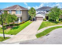 Charming two-story home boasts a well-manicured lawn and a long driveway leading to an attached two-car garage at 6125 Anise Dr, Sarasota, FL 34238