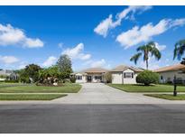 Charming home featuring a well-manicured lawn and a long driveway leading to the attached garage at 6643 Butlers Crest Dr, Bradenton, FL 34203
