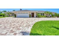 Charming home with brick driveway, manicured lawn, and lush tropical landscaping at 7913 19Th Avenue W Dr, Bradenton, FL 34209