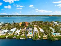Waterfront home featuring private pool, lush landscaping, and spectacular bay views on a sunny day at 8234 Midnight Pass Rd, Sarasota, FL 34242
