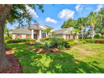 Beautiful home featuring a well-manicured lawn, lush landscaping, and mature trees at 8930 Bloomfield Blvd, Sarasota, FL 34238